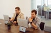 Two colleagues from prodot are sitting at a conference table in a meeting