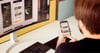 Ein Mann hält ein Smartphone in der Hand, auf der die Kienzle Driver Scoring App zu sehen ist.